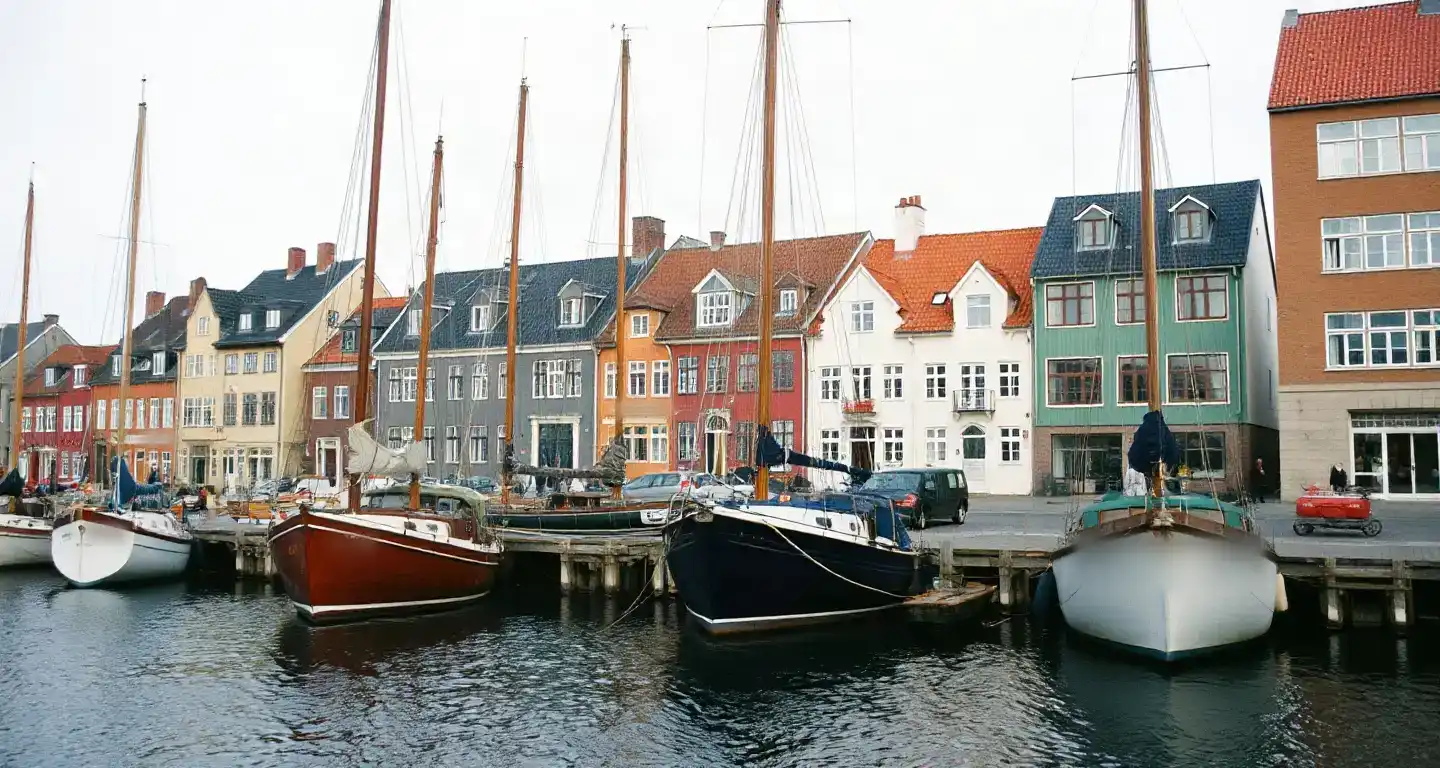 Colourful harbour houses and wooden boats along a canal in Copenhagen, Denmark